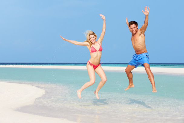 Couple Jumping On Beautiful Tropical Beach - Φωτογραφία, εικόνα