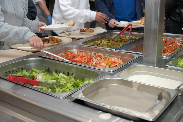 шведський стіл у дитячій їдальні діти беруть харчові салати м'ясний рис
 - Фото, зображення
