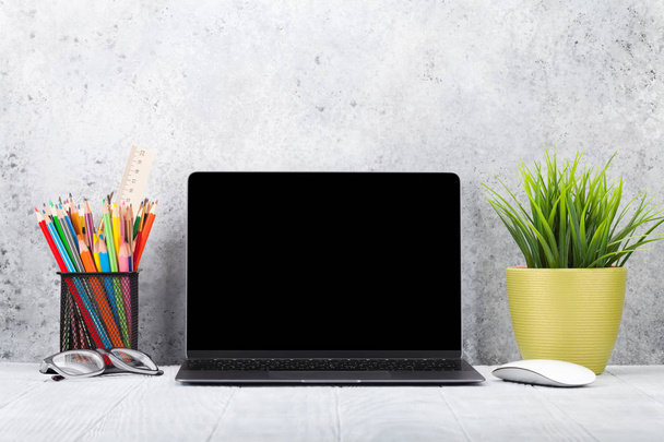 офисное рабочее место с чистым ноутбуком, зеленым заводом и аксессуарами
 - Фото, изображение
