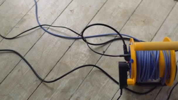 Drähte, die an das elektrische Verlängerungskabel angeschlossen sind, Drähte auf dem Boden, elektrische Geräte, elektrisches Netzwerk - Filmmaterial, Video