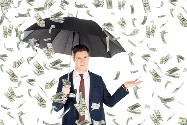 exitoso hombre de negocios en traje con paraguas gesticulando bajo la lluvia de dinero
 - Foto, Imagen