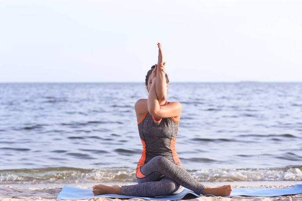 Kobieta praktykowania jogi na brzegu morza - Zdjęcie, obraz