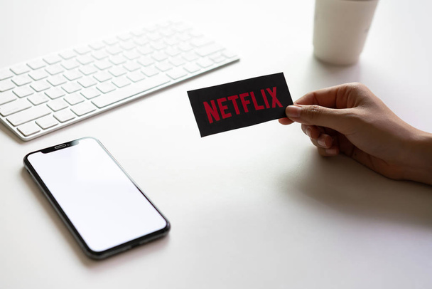 Bangkok, Thailand - March 12, 2019 : Women holding a paper label on the Netflix screen. Netflix is an international leading subscription service for watching TV episodes and movies. - Foto, imagen