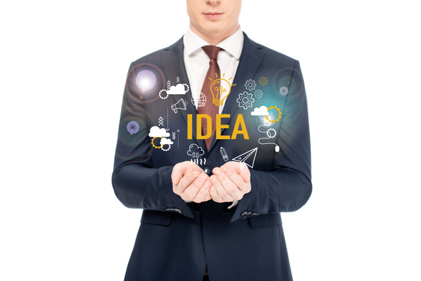 cropped view of businessman in suit with outstretched hands and idea lettering and icons above isolated on white - Foto, immagini