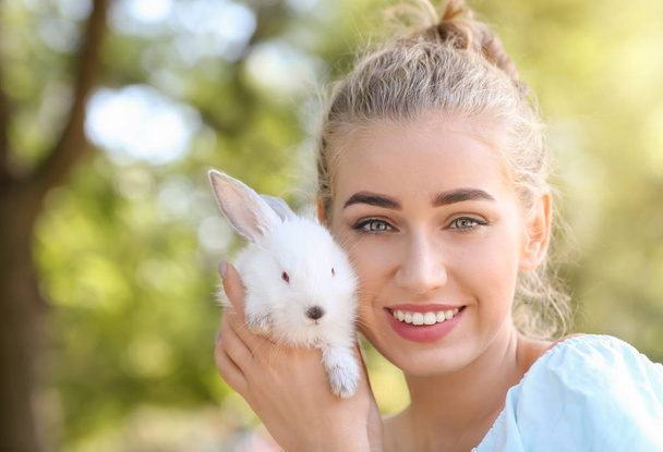 Beautiful young woman with cute rabbit outdoors - Foto, Bild