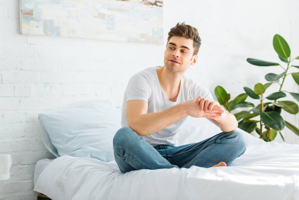 selective focus of handsome man sitting on bed at home - Photo, Image