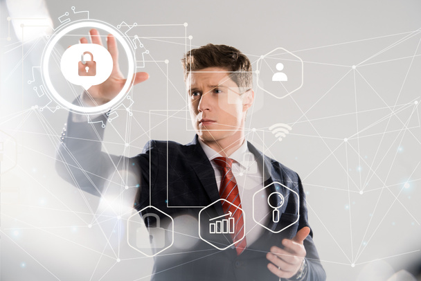 handsome businessman in suit pointing with hands at internet security illustration in front  - 写真・画像
