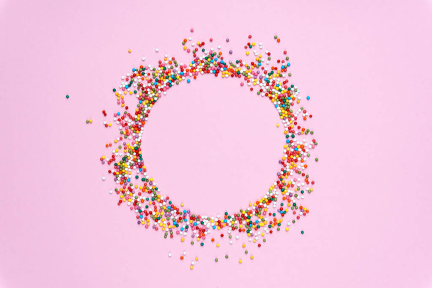 Round frame of colored sweets on a pastel colored background. Mi - Photo, Image