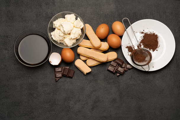 Ingredients for cooking tiramisu - Savoiardi biscuit cookies, mascarpone, cream, sugar, cocoa, coffee and egg - Foto, Imagen