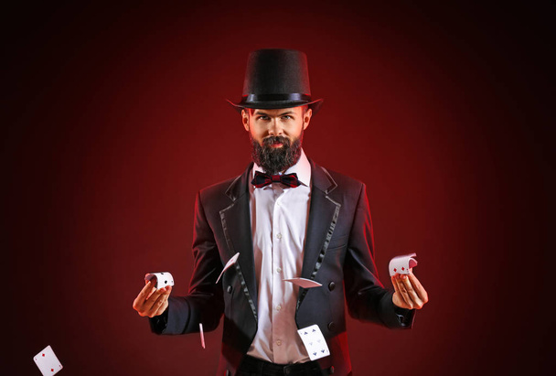 Magician showing tricks with cards on dark background - Photo, image