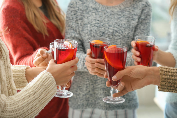 Друзья пьют восхитительное глинтвейн на вечеринке
 - Фото, изображение
