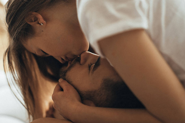 Close-up of young romantic couple is kissing and enjoying the company of each other at home - Photo, Image