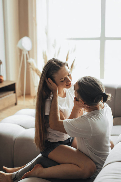 Young romantic couple is kissing and enjoying the company of each other at home - Photo, Image