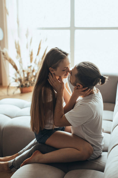Young romantic couple is kissing and enjoying the company of each other at home - Foto, afbeelding