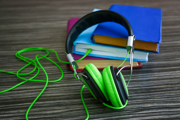 Moderni kuulokkeet ja kirjoja puinen tausta. Äänikirjan käsite
 - Valokuva, kuva