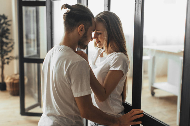 Young romantic couple is kissing and enjoying the company of each other at home - Foto, Bild