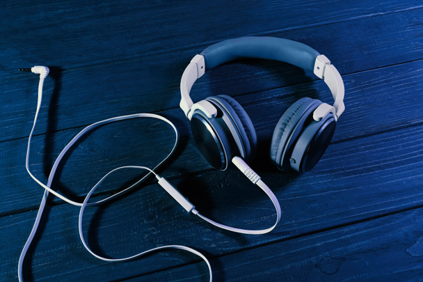 Modern headphones on color wooden background - Photo, Image