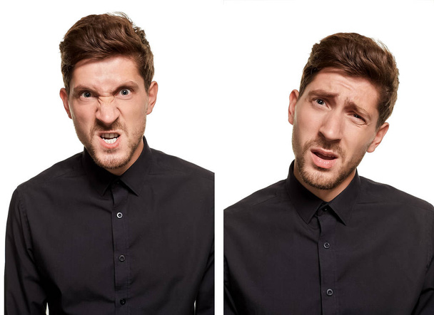 Handsome man in a black shirt makes faces, standing against a white background - Photo, Image