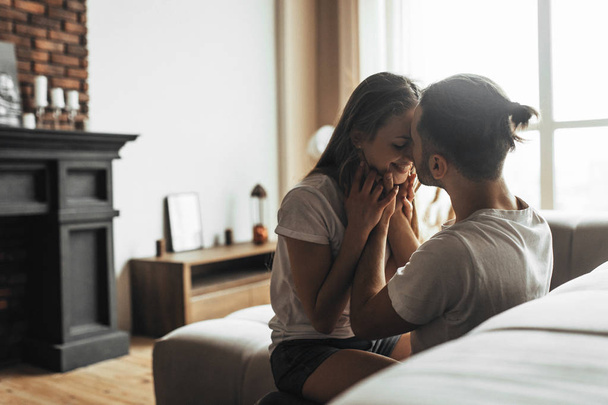 Young romantic couple is kissing and enjoying the company of each other at home - Photo, image