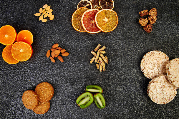 Snacks saludables - variedad de barra de granola de avena, arroz crips, almendras, kiwi, naranja seca
 - Foto, Imagen