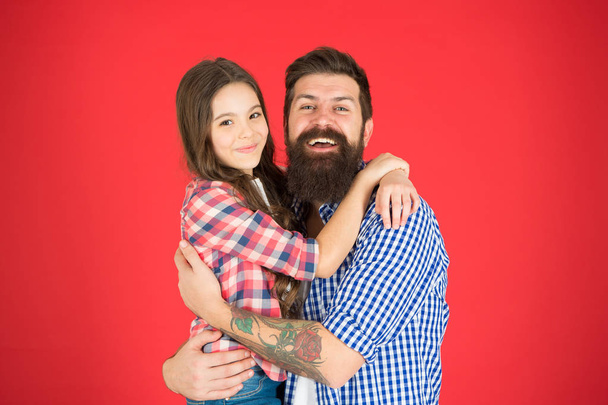 Happy moment. Man bearded father and cute little girl daughter on red background. Celebrate fathers day. Family values concept. Family bonds. Friendly relations. Father hipster and his daughter - Photo, image