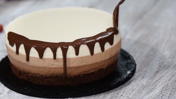 Drievoudige chocolademousse taart versieren met een gesmolten chocolade. - Video