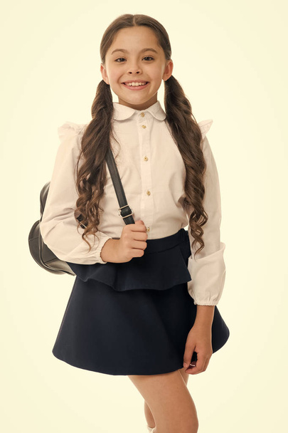 Learn how fit backpack correctly for school. Schoolgirl cute in formal uniform wear backpack. School backpack concept. Follow these tips. Right and wrong ways to wear backpack to prevent pain - Photo, Image