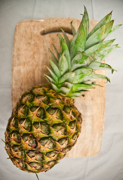 Enorme ananas op cutting board fisheye uitzicht - Foto, afbeelding