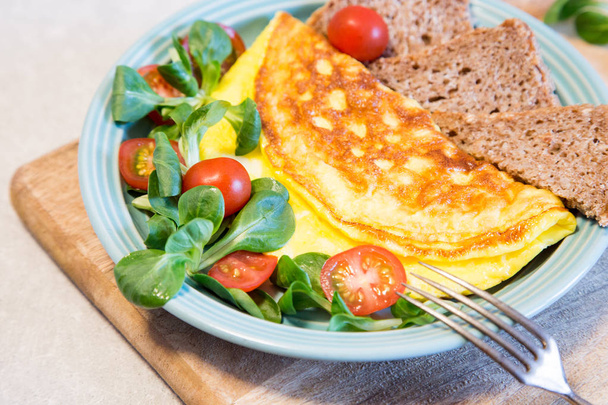 hausgemachtes Omelett mit Salat auf Teller. gesundes Ernährungskonzept - Foto, Bild