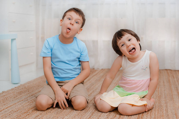 Children, boy girl, naughty floor room They grimace laugh. amusing. Kids bullies Naughty jokers childrens fun Restless - Photo, Image