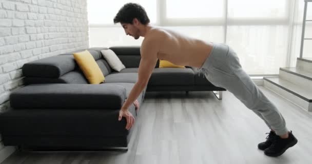 Young caucasian man exercising at home. Hispanic male athlete training for wellness, leisure, fitness, healthy lifestyle in domestic gym. Latin people, sport activity. Biceps push-up backward grip - Felvétel, videó