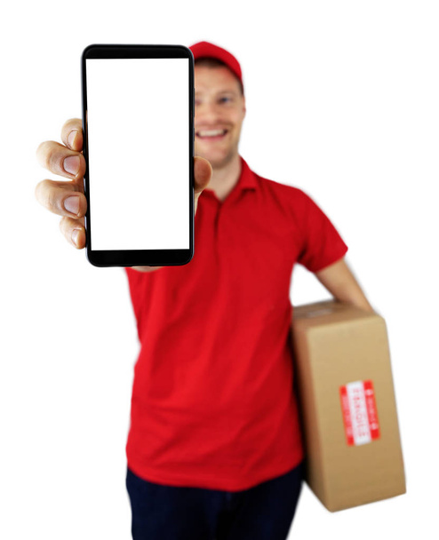 livreur souriant montrant smartphone avec écran blanc - Photo, image