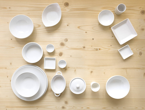 collection of modern white crockery on light wooden background - Foto, immagini
