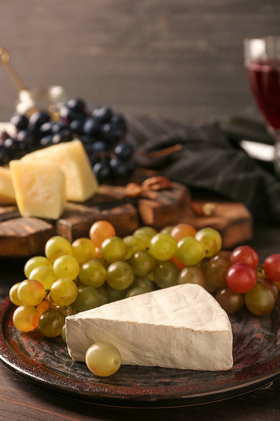 Plate with fresh ripe juicy grapes and brie cheese on table - Photo, Image