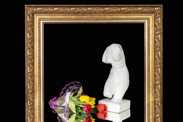Buquê de tulipas e um busto de Vênus em uma armação de pinturas
 - Foto, Imagem