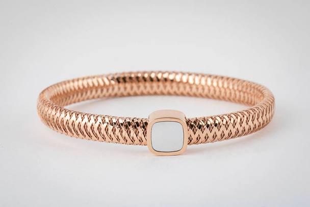 Female, rose gold wicker bracelet with stone in the middle, in the shape of a square isolated on a white background. - Photo, Image