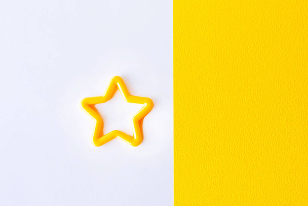 Stern auf weißem und gelbem Hintergrund. Ansicht von oben. flach lag. Kopierraum für Text - Foto, Bild