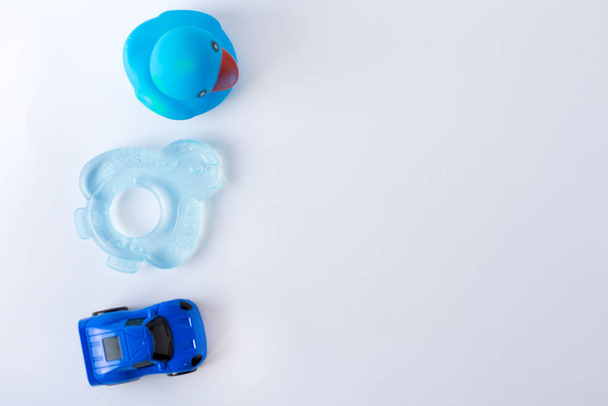 Baby-Boy-Accessoires und blaues Spielzeug auf weißem Hintergrund mit Leerraum für Text; Draufsicht, flache Lage - Foto, Bild