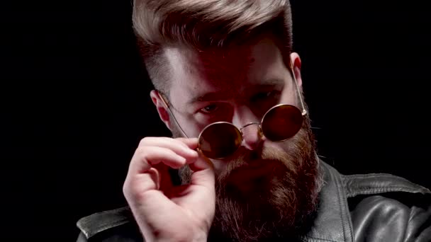 Homme à la longue barbe décollant et portant ses lunettes de soleil dans une pièce sombre
 - Séquence, vidéo