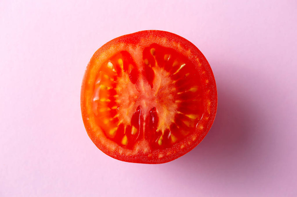 Feche o tiro de um tomate vermelho em um contexto rosa
 - Foto, Imagem