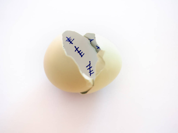 Un uovo rotto con dentro un conto alla rovescia e una piuma su uno sfondo blu pastello. Concetto di libertà
 - Foto, immagini
