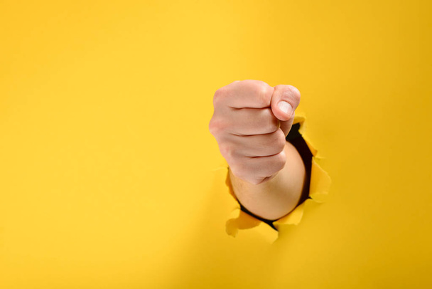 Fist broke yellow paper wall - Foto, Imagen