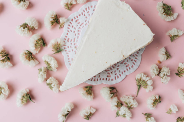 кусочек вкусного свежего сырного торта и лепестков цветов
 - Фото, изображение