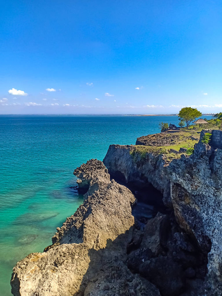 Limpia el mar de coral verde y azul en la playa de Uluwatu en un día soleado de verano. Océano roca, cielo, buena composición para tomar fotos para usar para decorar la imagen de fondo. Isla de Bali, Indonesia
.   .   - Foto, imagen