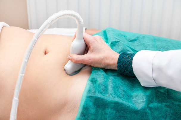 doctor abdominal ultrasound examine clinic patient body hand scanning green test USI waves non-invasive - Foto, imagen