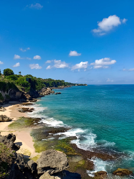Clean green and blue coral sea ocean at Uluwatu beach on a sunny summer day. Ocean rock, sky, good composition to take pictures to use to decorate the background image. Bali island, indonesia.   .   - Fotoğraf, Görsel