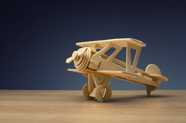 zabawki drewniane retro samolot na tle drewniany stół dla podróży  - Zdjęcie, obraz
