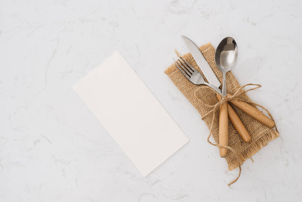 Concept of simple organic food - laconic design cutlery set on rustic wooden table and linen tissue. Top view. Copy space. - Photo, image