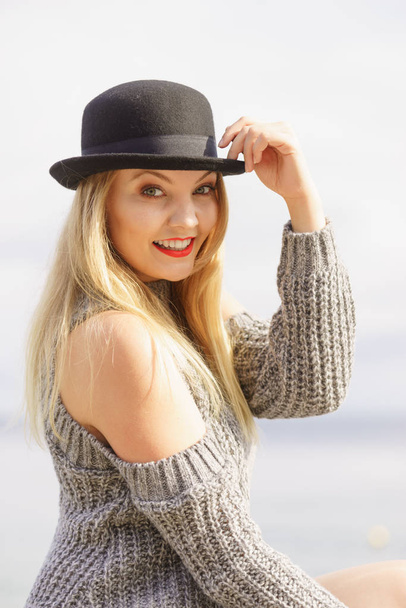 Woman wearing fedora and jumper outdoor - Photo, image