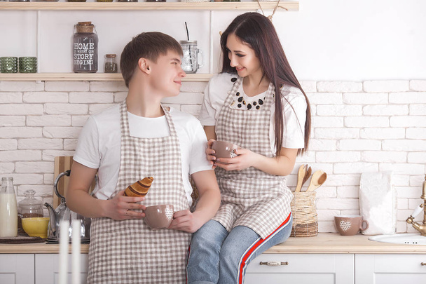 junges Paar, das Spaß an der Küche hat. Familie kocht zusammen. attraktive Mann und schöne Frau auf Küche Hintergrund. - Foto, Bild
